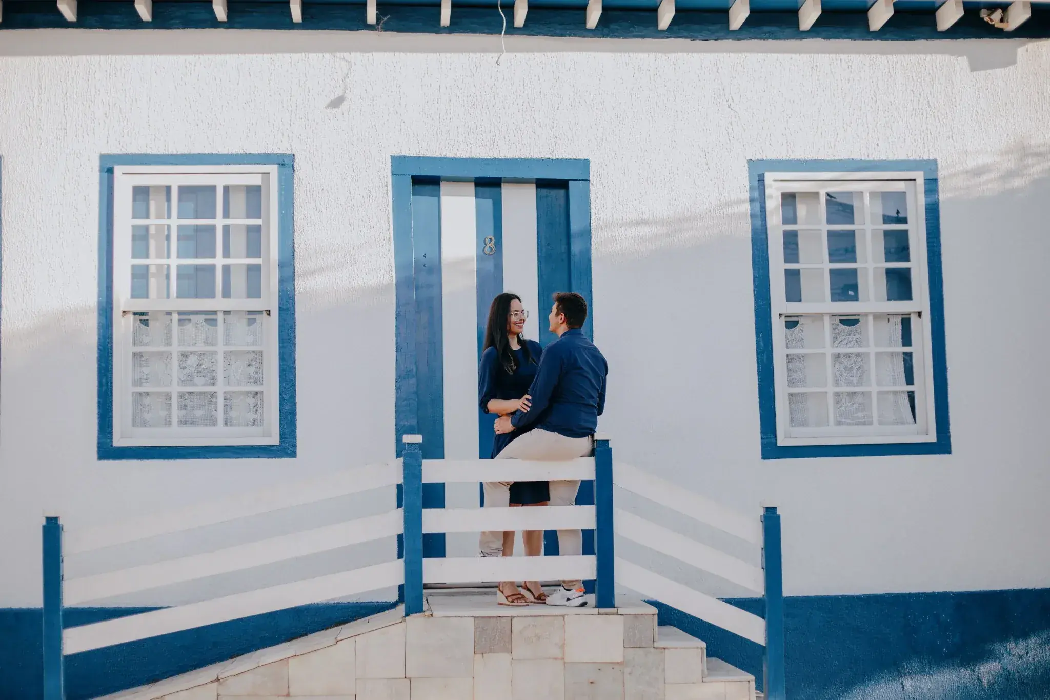 Pareja frente a una casa blanca